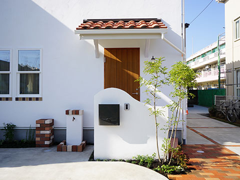 江戸川区で自然素材の注文住宅を建てるニットー住宅 白い壁とレンガのアクセントが映える自慢の外観デザインを