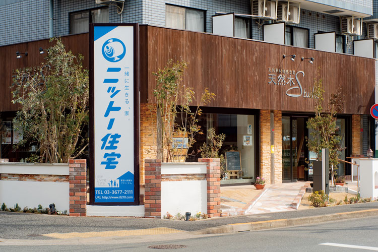 江戸川区で自然素材の注文住宅を建てるニットー住宅 ニットー住宅の青い社名看板と天然木スタジオの外観